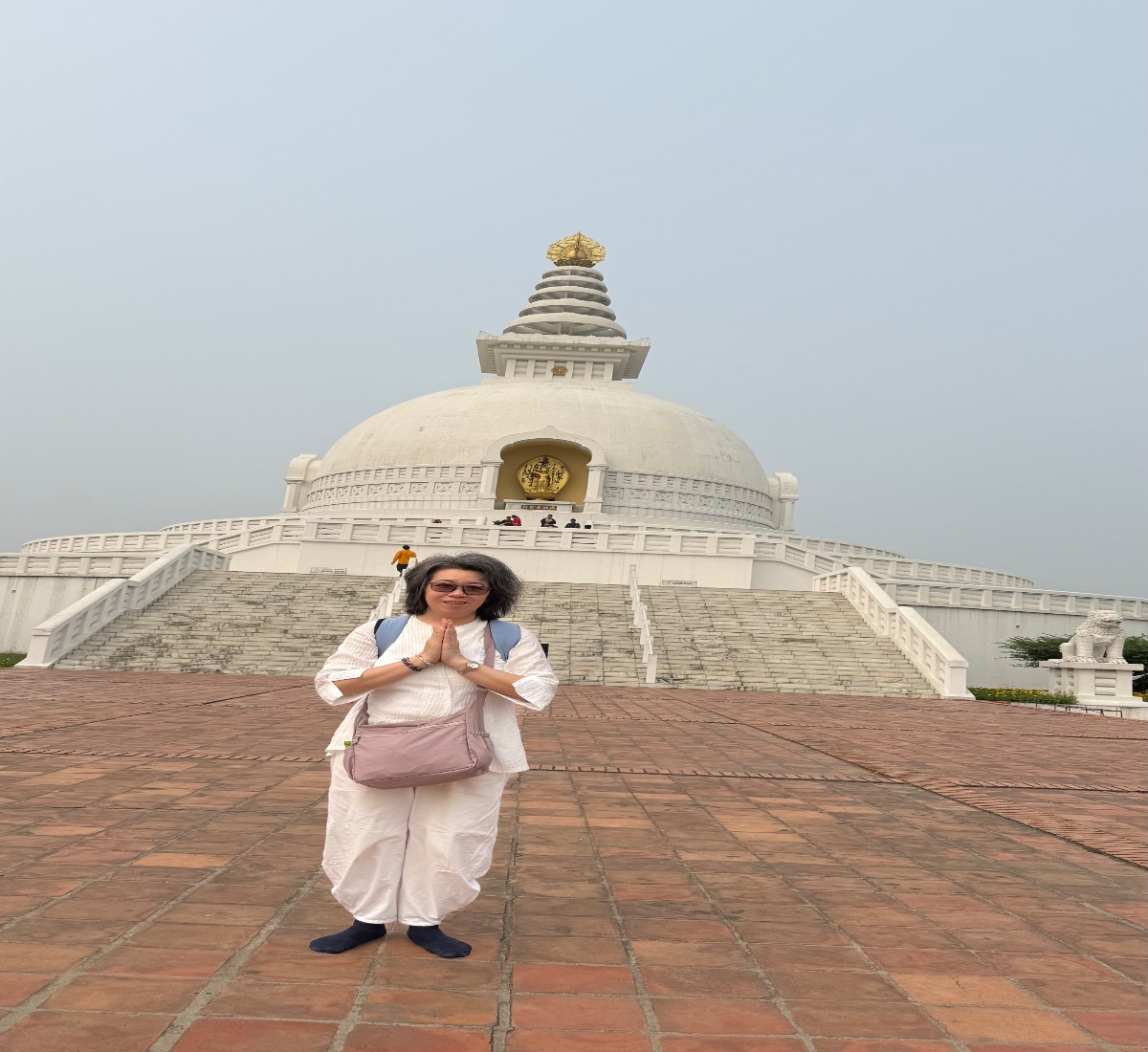 Tourist taking a picture with the World Peace Pagoda in Lumbini