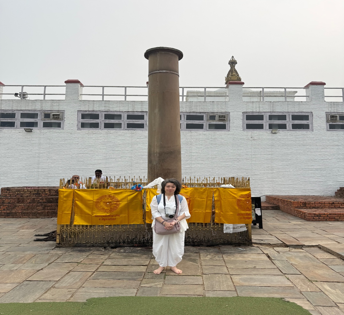A senior pilgrim at the Ashoka Pillar in Lumbini for a Buddhist Pilgrimage tour