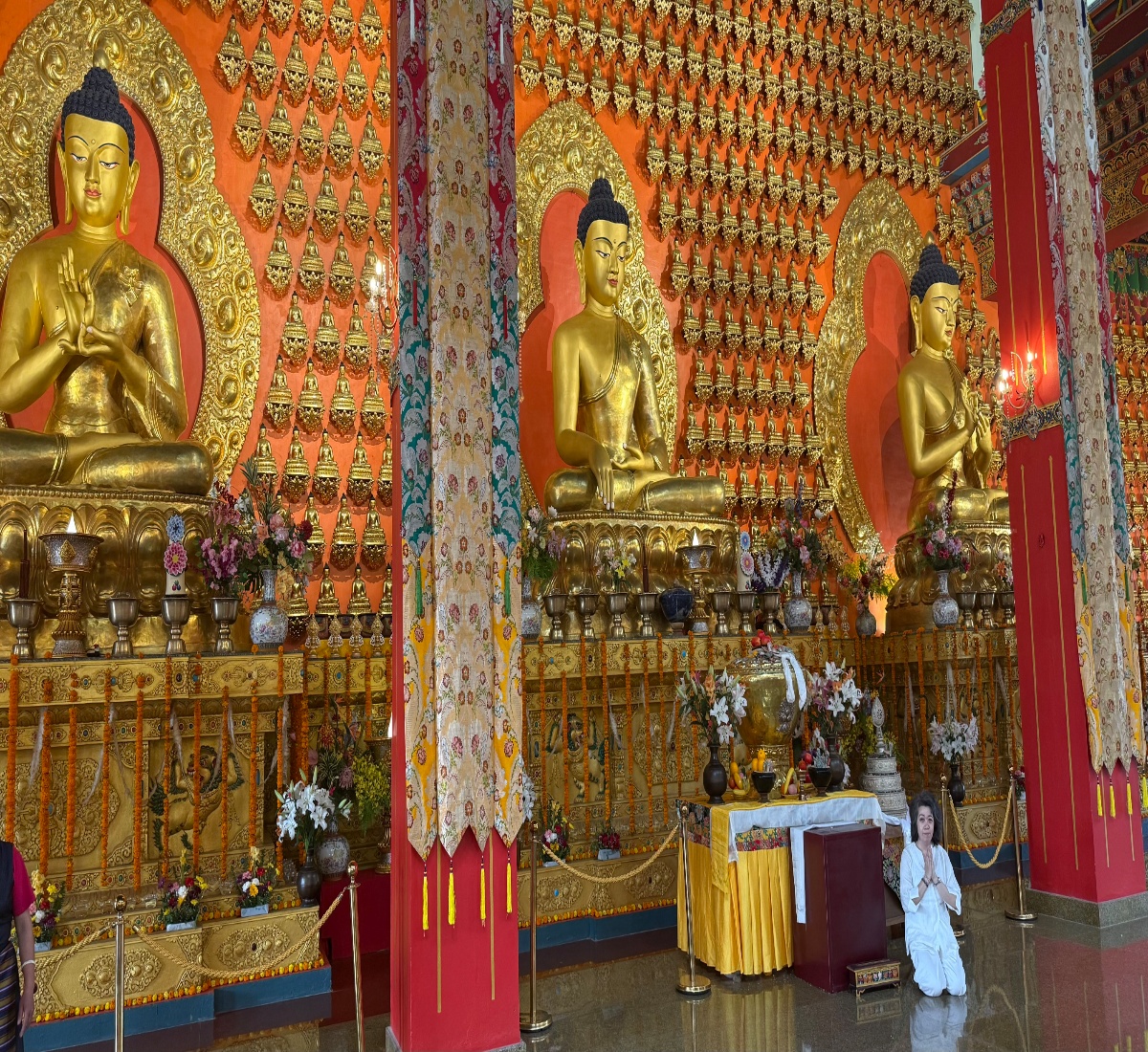 a senior pilgrim offering prayers and meditating inside a Buddhist monastery in Nepal