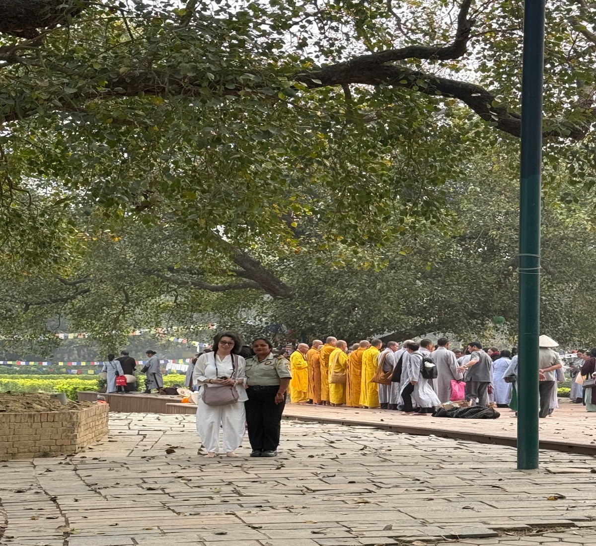 Senior Buddhist pilgrim in Nepal with monks in the background